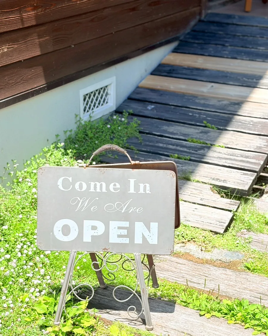 「Come In We Are OPEN」の看板が置かれた店の入口