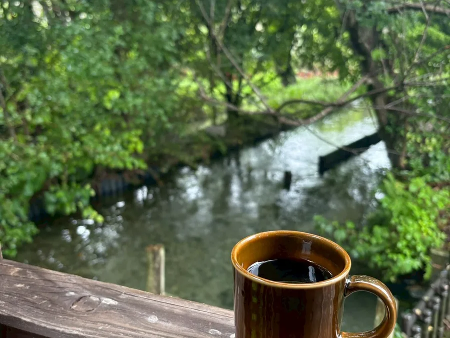 テラスの手すりに置いたコーヒーと清流